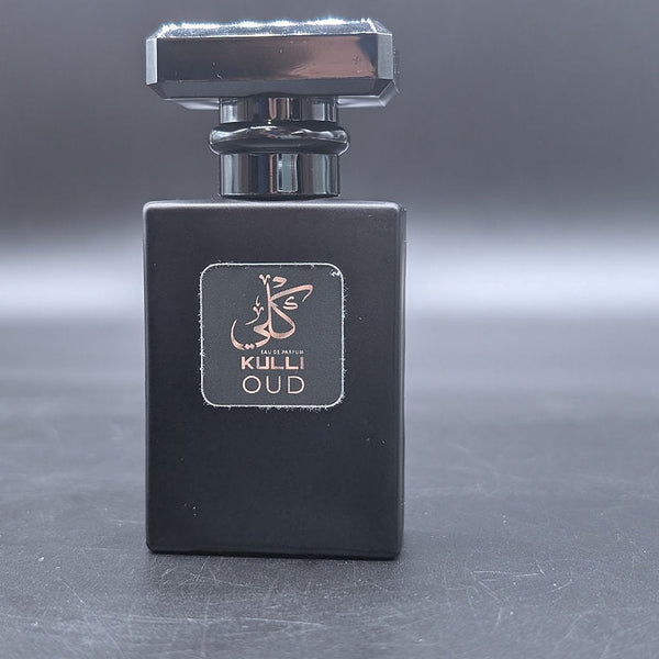 Black perfume bottle with a silver cap on a reflective surface